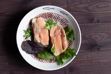 Open salmon sandwiches  with green salad leaves in plate on wooden table