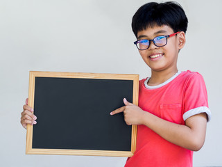 Little boy holding blank backboard or chalkboard against background. Education, shopping and sale concept.