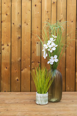 Glass, porcelain and ceramic flower vases on a wooden background.