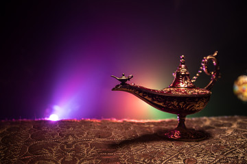 Lamp of wishes concept. Antique Aladdin arabian nights genie style oil lamp with soft light white...