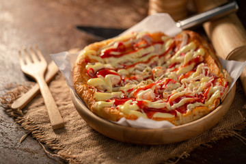 Close up of tasty homemade seafood topped pizza fusion food style on wooden tray