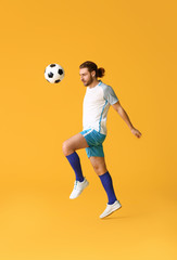 Fototapeta na wymiar Male football player on color background