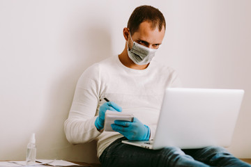 Fototapeta na wymiar man wearing face mask and medical gloves work remote at home