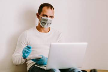 Fototapeta na wymiar man wearing face mask and medical gloves work remote at home