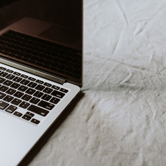 Laptop on grey linen table cloth.