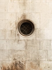 Little round window with iron grade. Minimal background. Vintage architecture concept.
