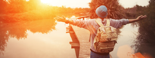 happy traveler on the lake with outspread hands looking. Wide screen panoramic