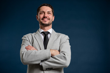 Low angle of business young handsome male standing with arms crossed