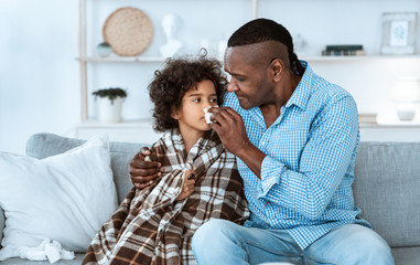 Infectious disease treatment. Cute sick child and granddad nursing her at home, blank space