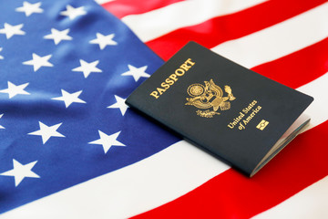 Naklejka premium Latest version of United States of America citizen Passport with biometric ID chip on USA national flag. Person identification document. Close up, copy space, background, top view, flat lay.