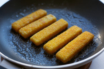 frying fish sticks in a pan. Cooking homemade. 