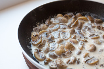 mushrooms in a creamy sauce in a pan. Homemade cooking.