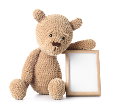 Teddy bear with photo frame on white background