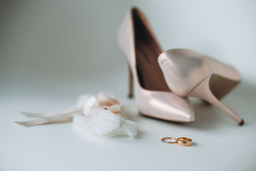 Wedding ring and shoes with gray background.