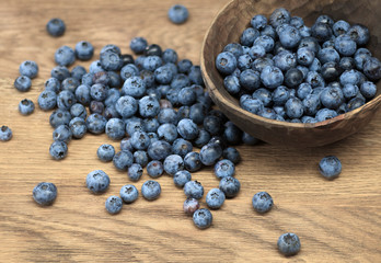 Freshly picked blueberries in bowl on wooden background. Selective focus. High resolution.
