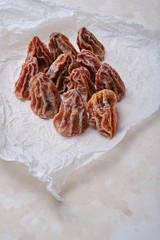 Dried persimmon on white crumpled paper. Top view.