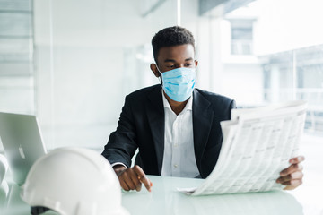 Handsome african businessman wear in medical mask with newspaper in the morning near business centre office