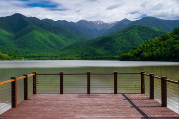 Pier on the lake on a background of mountains and sky. 
