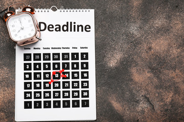Calendar with alarm clock and text DEADLINE on dark background
