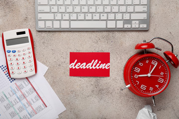 Word DEADLINE with alarm clock, calculator, documents and computer keyboard on grey background