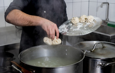 Chef coocking georgian khinkali or japanese wonton. Traditional meal 