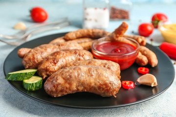 Plate with tasty grilled sausages and sauce on table