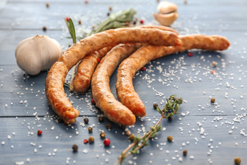 Tasty grilled sausages and spices on table