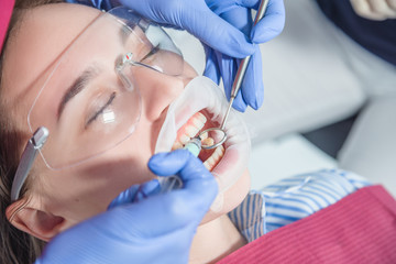 A dentist examines a patient, close-up of a patient with an open mouth next to which dental objects. The concept of health care and treatment in medical facilities