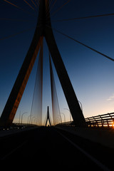 The silhouette of the bridge against the sunset sky. Silhouette of a cable-stayed bridge .