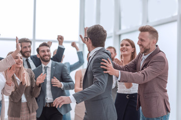 Obraz premium group of cheerful company employees congratulating their colleague