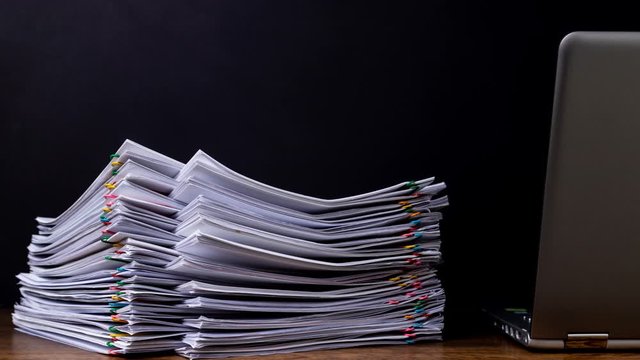 4K Stop motion - Stack overload business document report paper with laptop, concept of working from home and social distancing prevent corona virus covid-19.