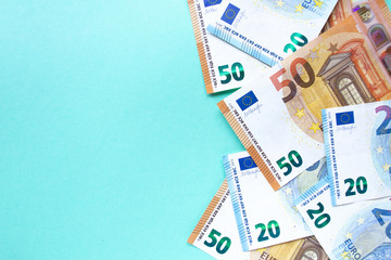 50 and 20 euro banknotes lie on a blue background on the right side. The concept of money and finance. With place for text.