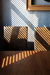Light and shadow from the window. Thin lines of light on the wall,armchair and table. The texture...