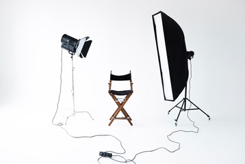 Empty photo studio with lighting equipment. Space for text. Vacant directors chair. The concept of...