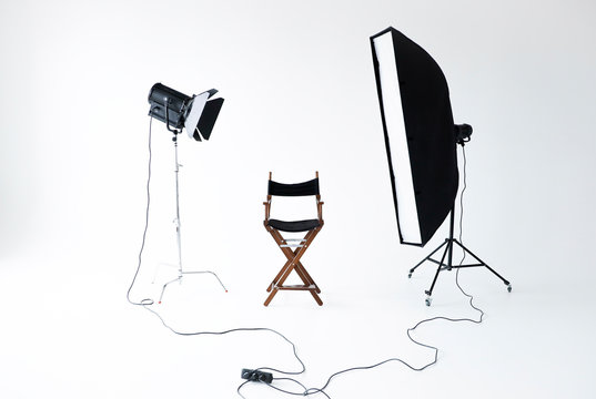 Empty photo studio with lighting equipment. Space for text. Vacant directors chair. The concept of selection and casting. Screensaver for your desktop. Job recruitment advertisement.