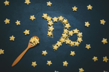 top view flat lay Capricorn, horoscope sign made from crispy corn stars on a black background