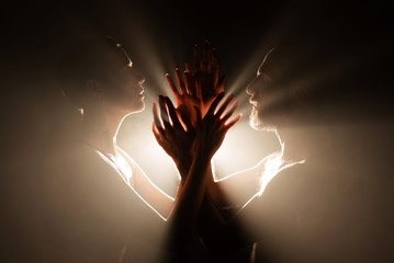 Woman and man silhouette rays of light in the dark