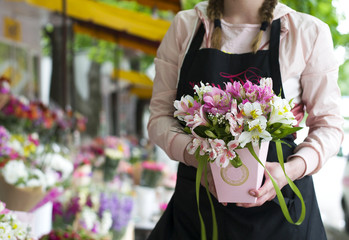 Colorful Alstroemeria flowers. A large bouquet of multi-colored alstroemerias in the flower shop are sold in the form of a gift box. The farmer's market. Close up.Girl is holding in hands a basket wit