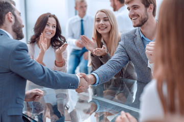 business team applauding the handshake of business partners.
