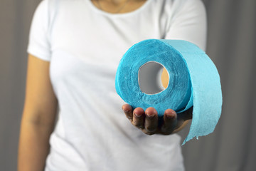 Blue toilet paper in a woman's hand