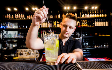 Bartender is making cocktail at bar counter. Fresh cocktails. Barman at work. 