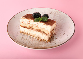Plate with tasty tiramisu on color background