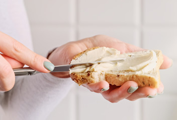 Female hands making a sandwich. Woman preparing breakfast, putting cheese on toast bread.