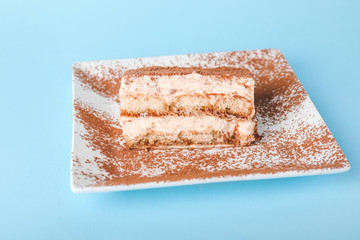 Plate with tasty tiramisu on color background