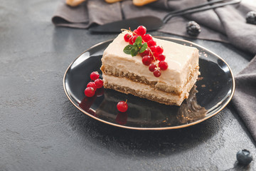 Plate with tasty tiramisu on dark background