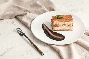 Plate with tasty tiramisu on table