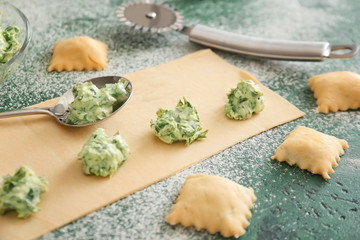 Preparing of tasty ravioli on color background