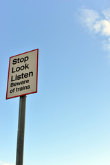 Stop Look Listen, beware of trains warning sign on road