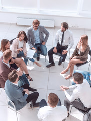 business training participants sitting in a circle and looking at the camera