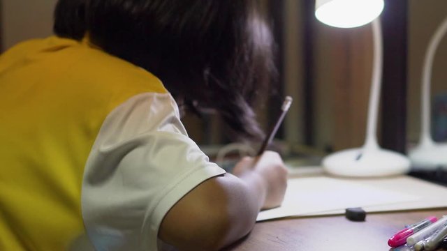 Asian children writting  and doing homework at home.Elementary happy Kid learning and reading book for study to the exam.Education concept.